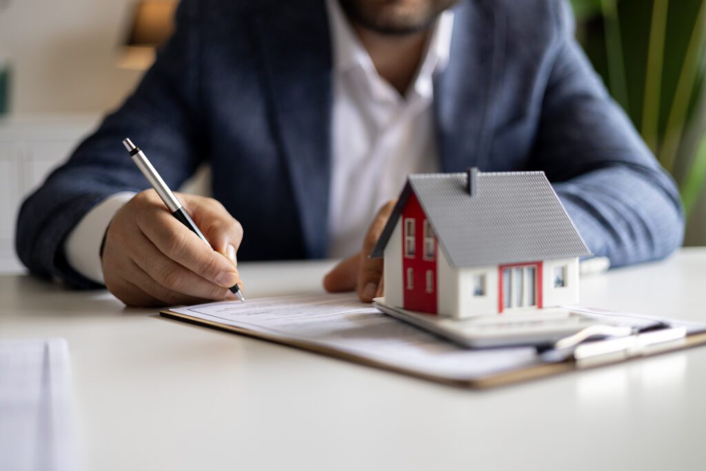 Signing real estate documents with model house